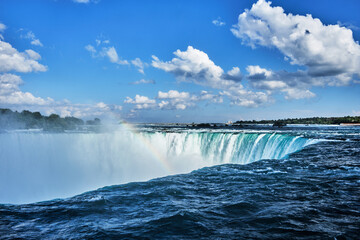 Fototapeta premium Looking across the brink of Horseshoe Falls, Niagara, Canada, with rainbow