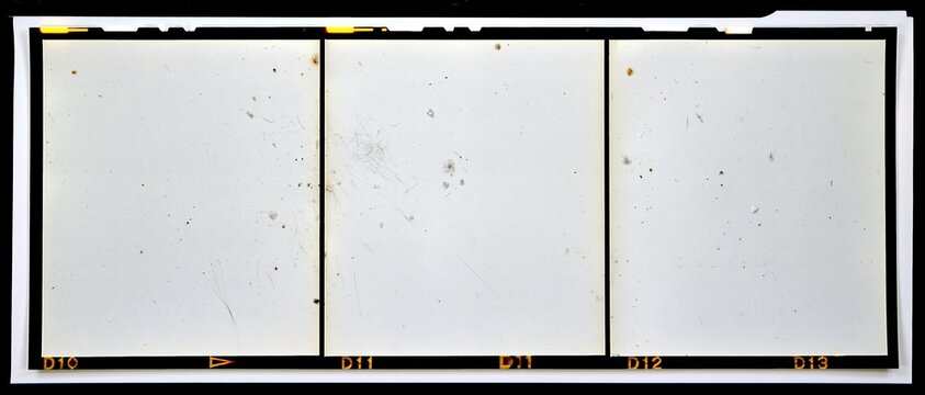 Three blank overexposed medium format film frames on a contact strip with orange labels and sprocket holes