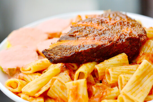 Pasta with red sauce and beefsteak.