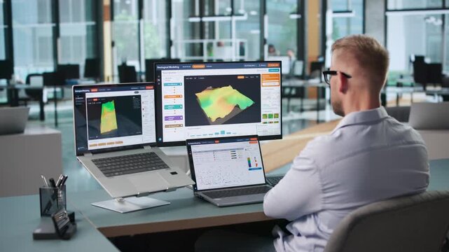 Geologist Examines 3D Subsurface Model Using Laptop