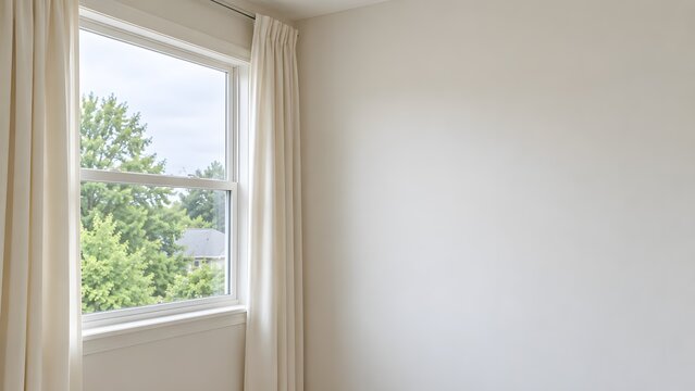 Open cream curtains framing a bright home window