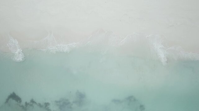 Top Down Aerial View of White Sand Beach and Gentle Surf