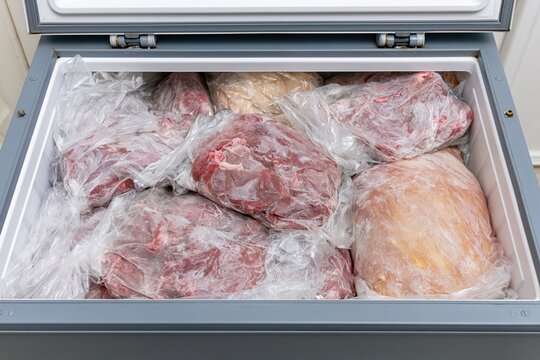 The Freezer Full of Frozen Meat Wrapped in Clear Plastic for Storage