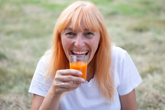 Happy Blonde Woman Eating a Sweet Snack at Outdoor Picnic