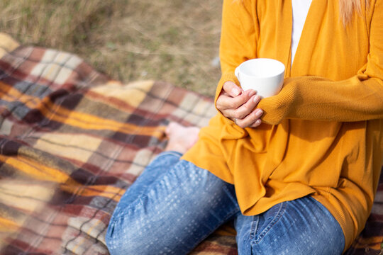 Woman in Mustard Yellow Sweater Holding White Cup at Cozy Autumn Picnic