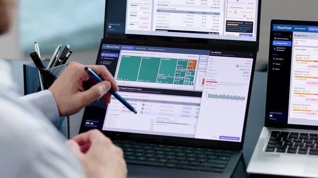 Fin-ops Manager Analyzes Cloud Spend Using Dual Laptops