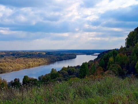 Beautiful landscape with river and blue sky with clouds in autumn.