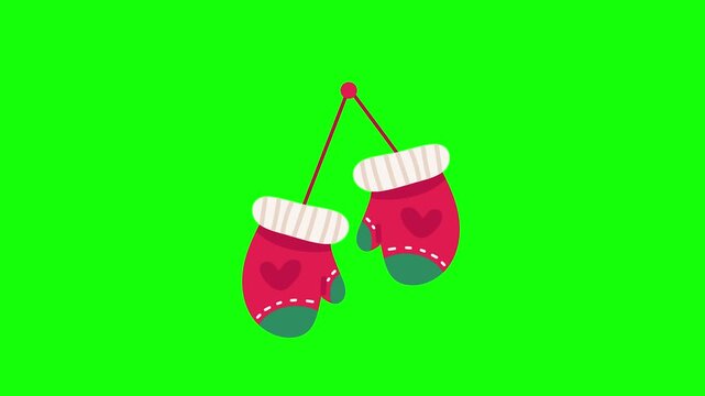 Charming hanging red winter mittens with cute heart details and striped cuffs on a green screen background, perfect for holiday projects.