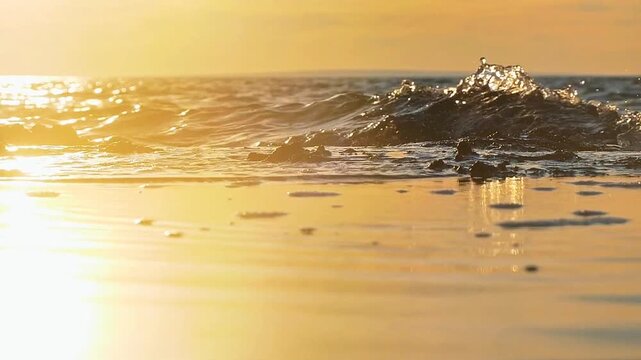 The calm ocean waves seemed to churn gently, splashing water toward the shore and shimmering with a golden glow from the afternoon sunlight.