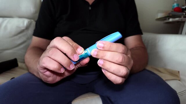 Individual removing safety cap from a GLP-1 Semaglutide auto injector pen for diabetes subcutaneous therapy, demonstrating patient medication management, self care, and chronic condition treatment.