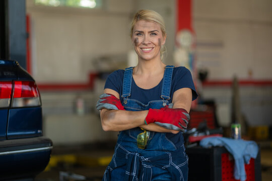 Female auto mechanic smiling in repair shop