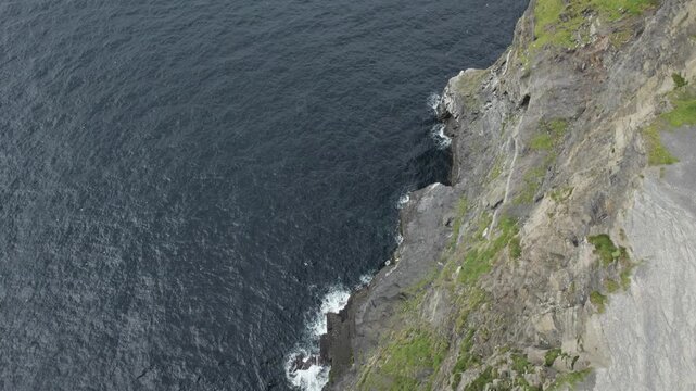 Coast of Ireland, Top Down Drone View of Steep Limestone Cliffs and Seabirds Flying Above Atlantic Ocean