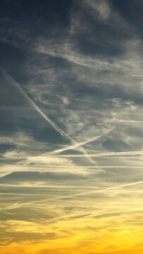 Aircraft contrails crossing the sky at sunset