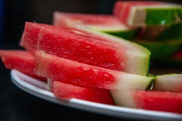  show fresh, ripe watermelon slices arranged neatly on a plate © And