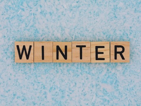 Winter. Wooden letters on an icy blue background.