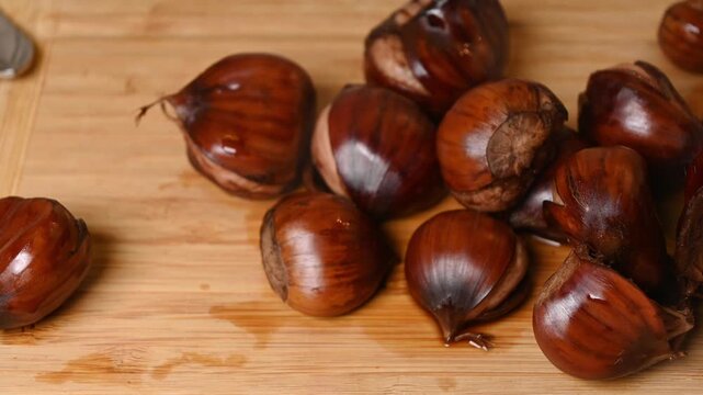 steaming hot boiled sweet chestnuts placed on a wooden cutting board