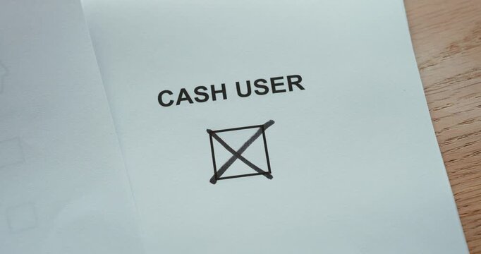 Close-up of a person marking a &ldquo;Cash User&rdquo; checkbox with a pen, representing cash payments, consumer payment preferences, financial habits and traditional payment methods.