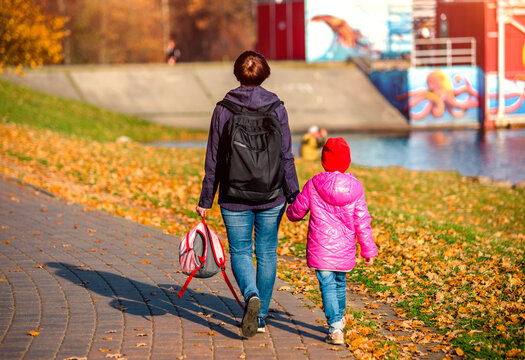 Mom walks with her daughter in the autumn Park
