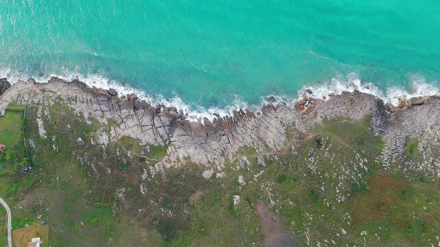 Aerial view of dramatic cliffs, sea stacks, and turquoise water along Costa Quebrada, Cantabria, Spain