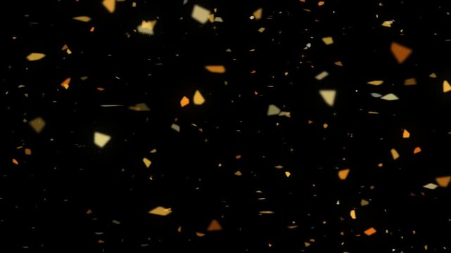 Gold foil flakes drifting sideways across a black background as irregular metallic pieces tumble and catch the light between their bright and shadowed faces