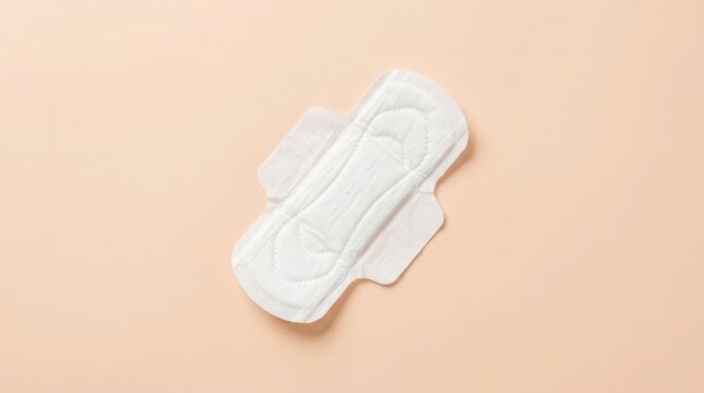 A detailed overhead studio shot of a white sanitary pad against a soft neutral beige background highlighting its absorbent core and protective