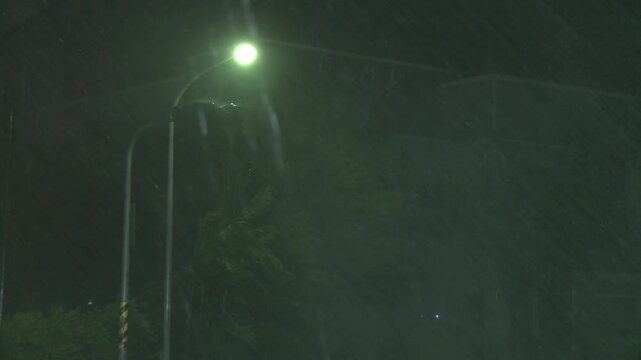 Sheets Of Rain Blow Past Street Light At Night During Tropical Storm Tembin