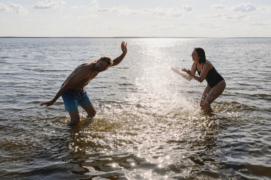 A happy couple splashes water in the sea during summer vacation