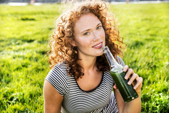 Portrait of redheaded young woman enjoying beverage