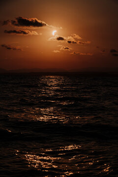 A solar eclipse illuminates the dramatic sky over the sea