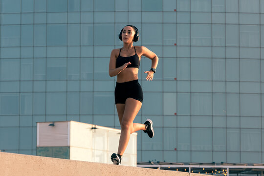 Athletic woman running outdoors in the city for fitness