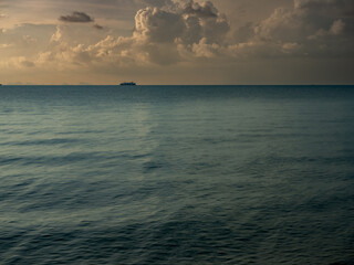 Tropical Seascape with Distant Ship Beneath Cloudy Sky © YEVGENIY