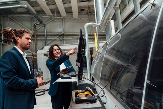 Businesswoman explains production to a businessman in the factory