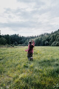 Woman explores green meadow enjoying freedom and nature