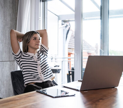 Woman relaxes at her desk in the home office