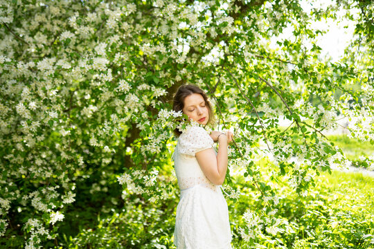 Woman enjoys blooming apple tree in spring
