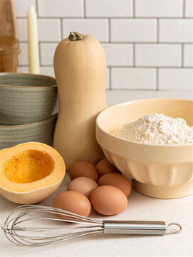 Contemporary autumn baking table with halved butternut squash and ingredients