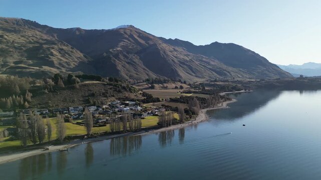 Wanaka tree stands in a beautiful New Zealand mountain landscape viewed from above with the Southern Alps and tranquil lake scenery creating a popular travel tourism destination