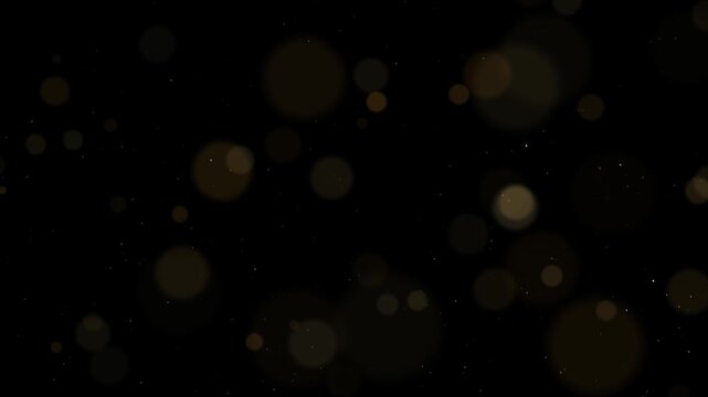 Soft gold bokeh circles drifting over fine glitter dust on a black background in a warm seamless looping light overlay