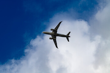Fototapeta premium Commercial passenger aircraft seen from below while approaching or departing Sylt Airport near Westerland on the North Sea island of Sylt, Germany.