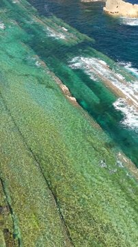 Aerial view of dramatic cliffs, sea stacks, and turquoise water along Costa Quebrada, Cantabria, Spain