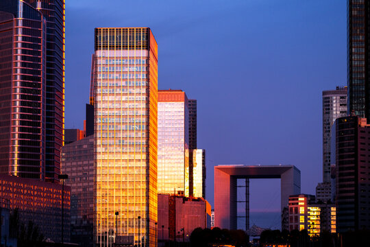 Office towers and glass buildings form a business skyline in Paris France as sunlight reaches the architecture and the office towers across the skyline