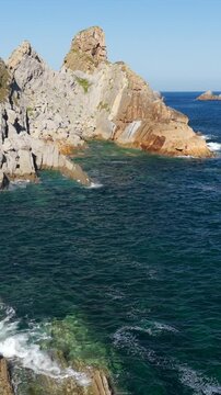 Aerial view of dramatic cliffs, sea stacks, and turquoise water along Costa Quebrada, Cantabria, Spain