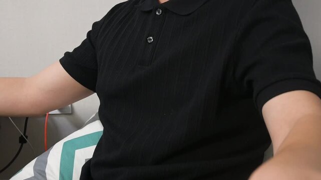 Young Man Wearing a Black Ribbed Polo Shirt Practicing Deep Breathing Indoors