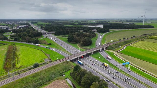 Traffic at a highway junction near Zwolle where the A28 and the A50 highways cross with a railroadbridge in the foreground in Overijssel The Netherlands.