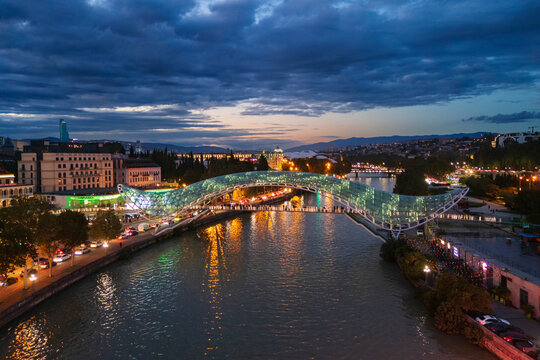 The bridge of peace illuminated over the mtkvari river at Dusk