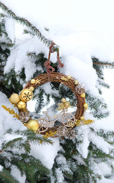 festive decor for Christmas, New year holidays. beautiful decorative wreath with bicycle figurine on snowy christmas tree outdoor. seasonal Gift idea for bicyclist