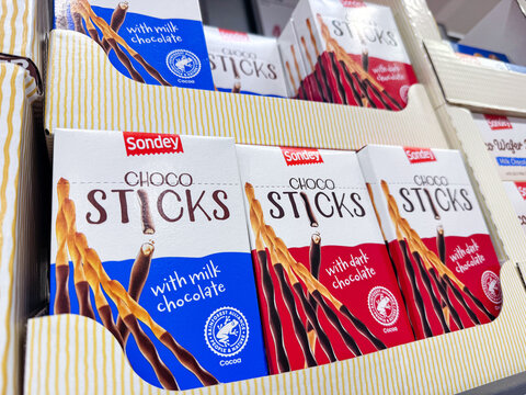 Prague, Czech Republic - September 17, 2026: Sondey Choco Sticks chocolate biscuit packages with milk and dark chocolate varieties displayed in a striped retail shelf tray