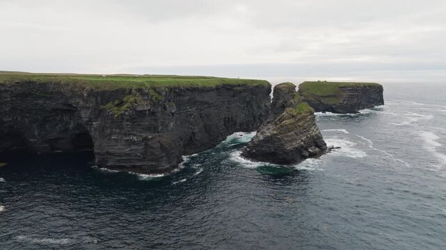 Kilkee Cliffs Ireland aerial view reveals spectacular Atlantic coastline with massive waves crashing against rugged rocks surrounded by beautiful natural scenery