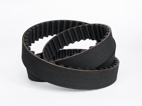 Coiled black automotive toothed timing belt isolated on white background