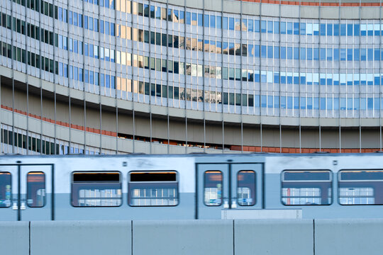 Train beside a curved office facade in Vienna Austria creates urban transport architecture where geometry connects the train and curved office facade
